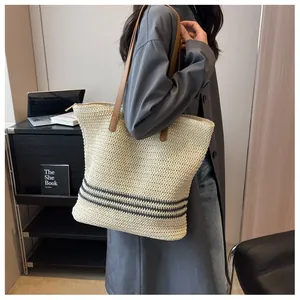 Détail du grand sac cabas tissé avec rayures noires et anses en cuir marron