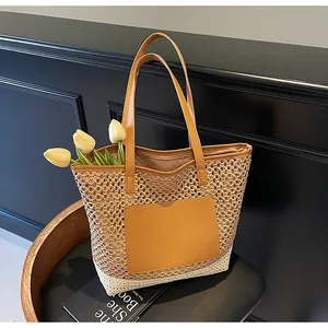 Dettaglio della borsa tote in paglia intrecciata con manici e tasca in cuoio