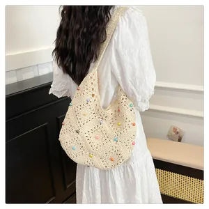 Detail of bohemian cream crochet shoulder bag with colorful beads on a female model