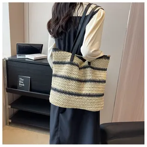 Détail du grand sac cabas tissé avec des rayures noires et beige pour la plage ou voyage