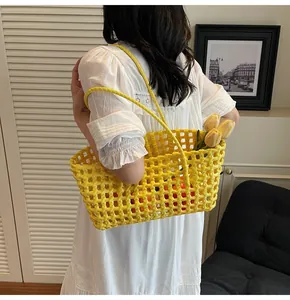 Detail showing the hand-woven yellow mesh texture and long handles of the summer beach bag