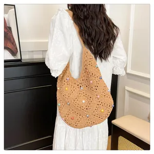 Detailed close-up of handmade crochet shoulder bag with colorful beads and knit patterns