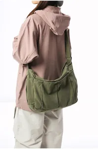 Close-up of army green vintage canvas messenger bag with pockets and wide shoulder strap