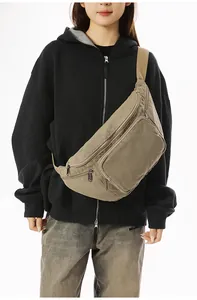 Detail view of khaki canvas crossbody bag with multi-pocket design and adjustable strap