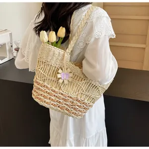 Dettaglio borsa tote in paglia intrecciata a mano con motivo traforato e manici a treccia