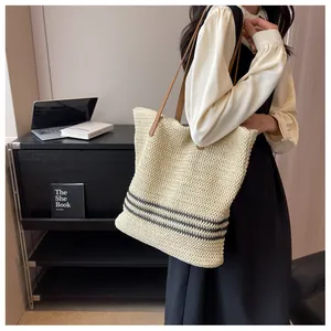 Détail du sac fourre-tout tissé bohème avec rayures noires et anses en cuir marron