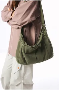 Detail of army green canvas messenger bag with wide strap and rugged texture