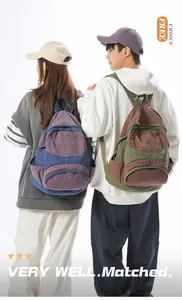 Rear view of models wearing color-block canvas backpacks in blue-purple and olive-brown