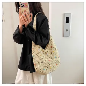 Detail of bohemian cream crochet bag with colorful bead accents and hollow knit patterns