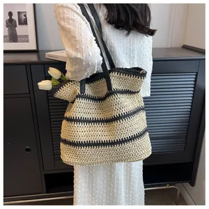 Détail d'un grand sac cabas tissé de style bohème avec rayures noires et anses en cuir