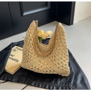 Close-up of beige crochet tote bag with hollow knit pattern and brown shoulder strap