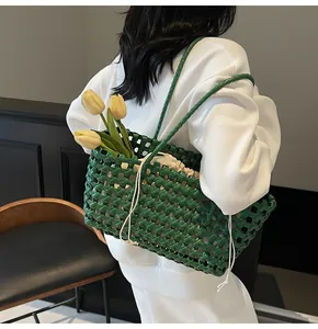 Detail of green woven tote bag featuring a mesh structure and beige drawstring inner pouch