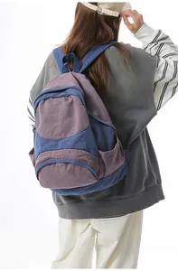 Detail view of purple and navy canvas backpack with adjustable straps on model
