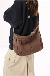 Detail of vintage brown canvas messenger bag showing side pockets and stitching
