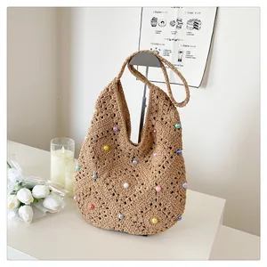 Detail of hand-woven hollow knit tote with colorful pearl accents for summer beach style