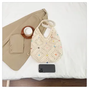 Flat lay of cream crochet tote bag with colorful beads and minimalist lifestyle props