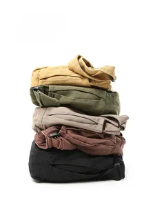Detailed stack of vintage canvas messenger bags in five colors with metal D-rings