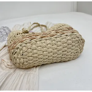Dettaglio ravvicinato della trama della borsa in paglia con inserto a righe marroni
