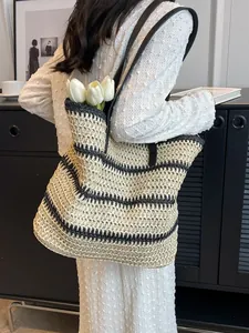 Sac fourre-tout bohème en paille rayée avec bandoulière noire pour plage et été chic
