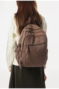 Zaino in tela marrone vista posteriore su modella con tasche multiple funzionali