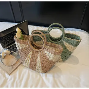 Detail of woven straw tote bags with circular handles and gold chain trim in vacation style