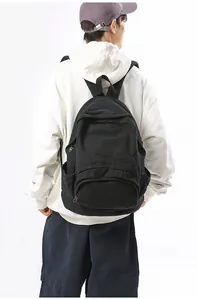Rear view of a black canvas backpack on a model showing daily casual style and fit