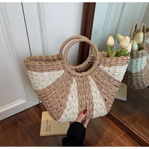Detail view of woven straw tote bag with metallic threads and circular handles