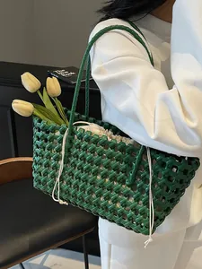 Dark green woven leather tote bag with drawstring inner pouch for beach and vacation