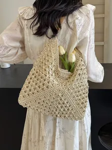 Handmade hollow woven straw shoulder bag in beige for summer beach vacations