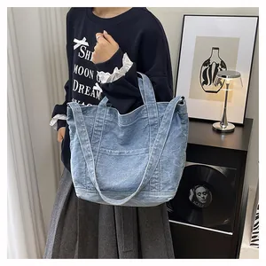 Close-up of light blue denim tote bag with reinforced stitching and dual shoulder straps