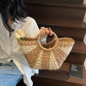 Close-up of a woven straw tote bag with dual-tone patterns and round handles for summer