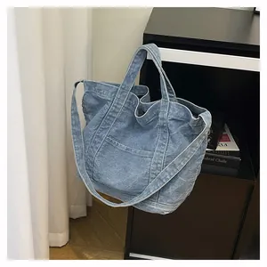 Close-up of vintage blue denim tote bag texture with white stitching and front pocket