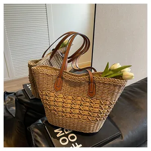 Detailed close-up of woven straw tote bag texture and reinforced leather handles