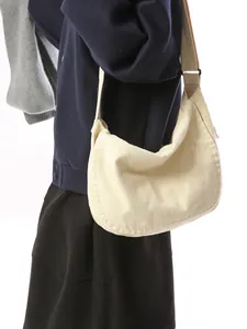 Large beige canvas crossbody bag for women with an adjustable wide shoulder strap