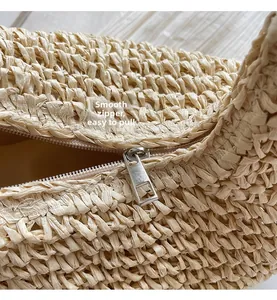 Detail of smooth metal zipper closure on bohemian woven straw beach handbag