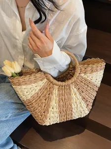 Handwoven straw beach bag with striped patterns and gold chain details for summer