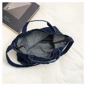 Internal view of the large denim tote bag showing the zipper closure and spacious interior