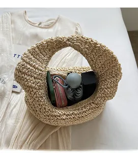 Detailed view of the spacious interior of a beige straw beach bag with daily essentials