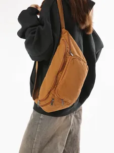 Brown canvas crossbody bag with large capacity and adjustable strap shown on model