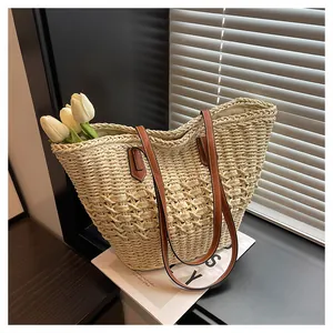 Close-up of woven straw tote bag with brown leather straps and cutout texture detail
