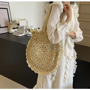 Detail of bohemian round straw bag featuring intricate crochet floral patterns and lace trim