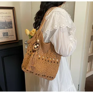 Detailansicht einer braunen Strick-Tote-Bag mit Strickmustern und hölzernen Perlen-Anhängern
