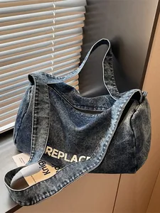 Deep blue denim cylinder crossbody bag with white REPLACE lettering and wide strap