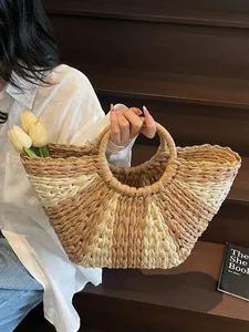 Handwoven straw tote bag in beige and brown with summer flowers for beach vacations