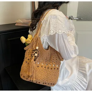Nahaufnahme der Häkeltasche mit Lochmustern und dekorativen Quasten aus Vintage-Holzperlen
