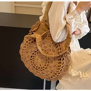 Detail of bohemian hollow out crochet straw bag with secure drawstring lining and handle