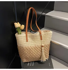 Détail du sac de plage en tissage creux avec anses en cuir et pompons décoratifs