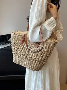 Large hand-woven straw tote bag with brown leather straps and hollow knit pattern