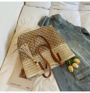Détail d'un cabas tissé à la main avec poignées en cuir marron et pompon décoratif