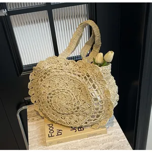 Detail of bohemian hollow-out crochet straw bag with double handles and floral patterns